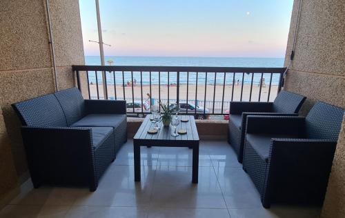d'un balcon avec des chaises et une table offrant une vue sur la plage. dans l'établissement Beach Haven, à Torrevieja