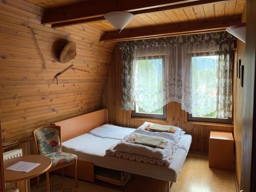 um pequeno quarto com uma cama e uma janela em "Jurkówka" em Szczyrk