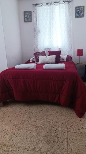 a bedroom with a red bed with pillows on it at Casas Calis Cancún in Cancún