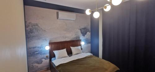 Schlafzimmer mit einem Bett mit Wandgemälde in der Unterkunft Rudy Kot in Danzig