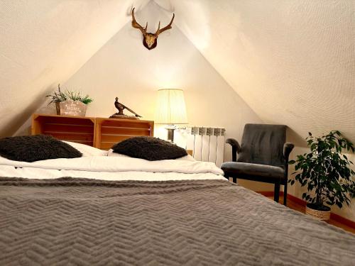 a bedroom with a bed and a chair and a lamp at Domek dla dwojga in Tylicz