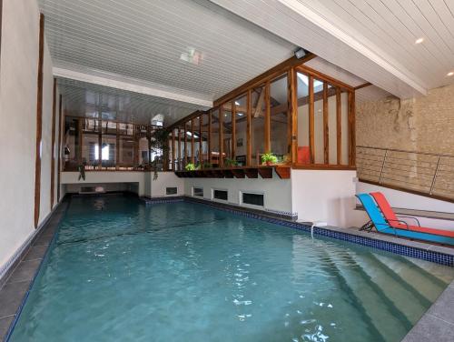 an indoor swimming pool with a table and chairs at Grange des Bardins in Villebois-Lavalette