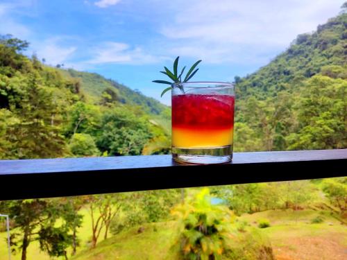 a drink in a glass sitting on a window sill at Hotel Rivel - Restaurant & Nature Retreat in Turrialba