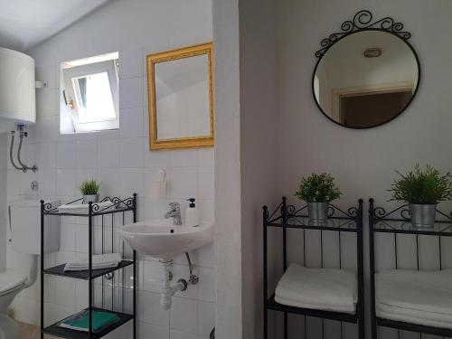 a bathroom with a sink and a mirror at Holiday home Voga in Maslinica