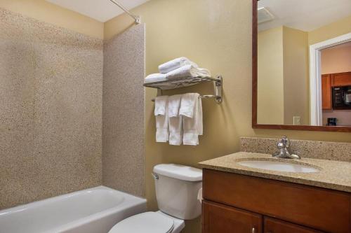 a bathroom with a toilet and a sink and a bath tub at Candlewood Suites San Antonio NW Near SeaWorld, an IHG Hotel in San Antonio