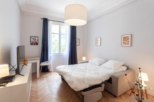 une chambre blanche avec un lit et un bureau dans l'établissement 26 Nice Parc Imperial studio, à Nice