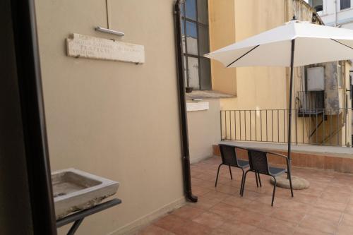 einen Tisch mit Sonnenschirm auf einem Balkon mit Stuhl in der Unterkunft GG-Grow - La Terrazza Di Bellavista in Neapel
