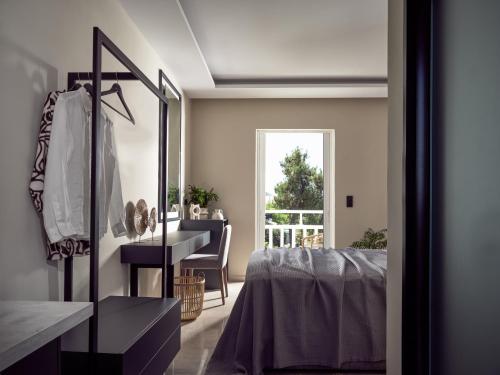 a bedroom with a bed and a desk and a window at Nastazia Studios in Laganas