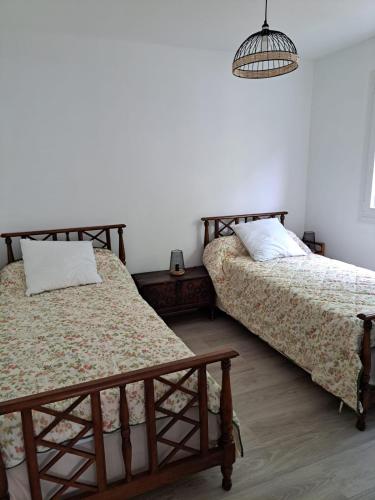 - une chambre avec 2 lits et une lampe pendant dans l'établissement Maison Biscarrosse plage 500m de l océan, à Biscarrosse