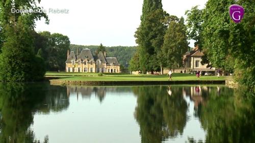 ein großes Haus vor einem See mit einem Gebäude in der Unterkunft Maison de Village Vexin site classé 1h Paris et Normandie grand jardin in Reilly