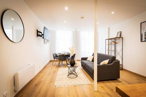 un salon avec un canapé et une table dans l'établissement L'Albatros 011 - Hypercentre * Cosy * Wifi, à Saint-Quentin