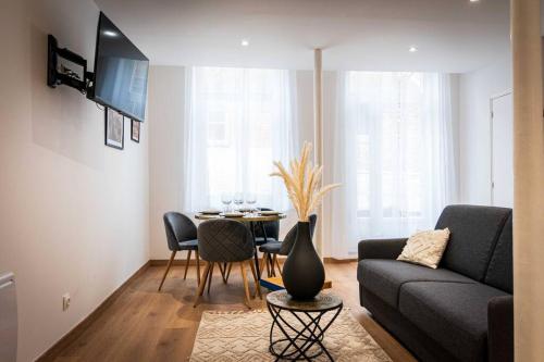 ein Wohnzimmer mit Couch und Tisch in der Unterkunft L'Albatros 011 - Hypercentre * Cosy * Wifi in Saint-Quentin