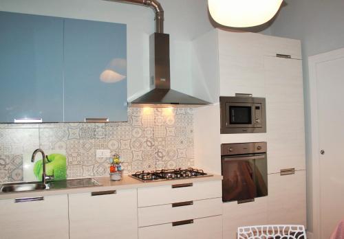 a kitchen with white cabinets and a stove top oven at InsideLecce in Lecce