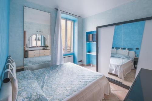 Dormitorio azul con cama y espejo en Matty's Home - Center - SEA View - FREE PARKING - Strategic area, en San Remo