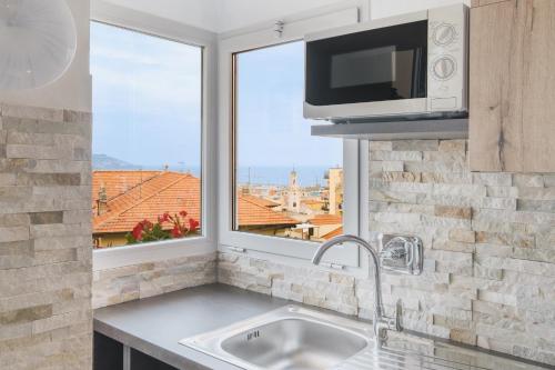 cocina con fregadero, microondas y ventana en Matty's Home - Center - SEA View - FREE PARKING - Strategic area, en San Remo