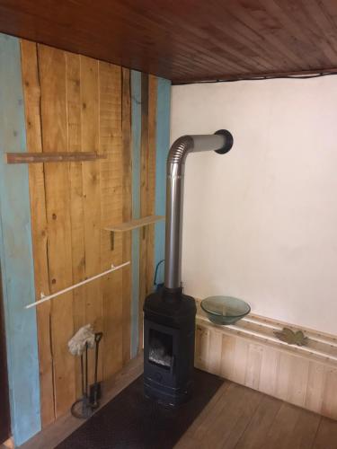 a wood stove in a room with a wall at Le refuge du berger in Choux