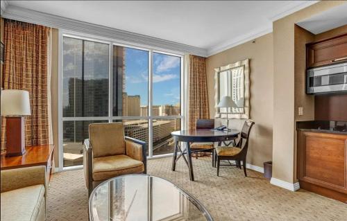 a living room with a table and chairs and a large window at Signature MGM Suite with Strip and Sphere View in Las Vegas