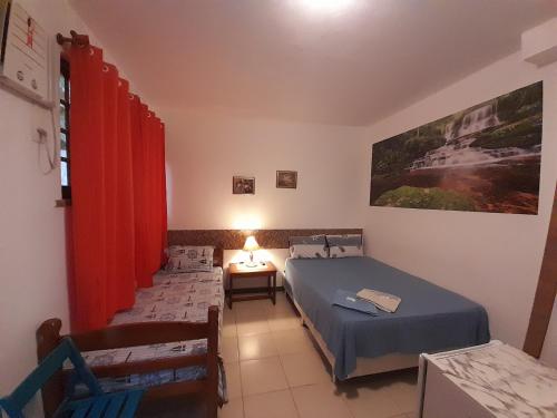 Un dormitorio con dos camas y una mesa con lámpara. en Albergue Rio Vermelho, en Salvador
