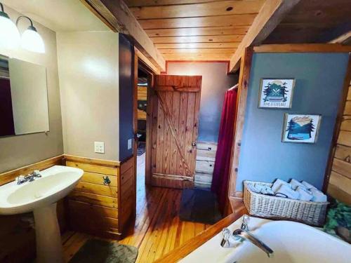a bathroom with a sink and a toilet and a mirror at The Loft at Bear Mountain log cabins in Eureka Springs