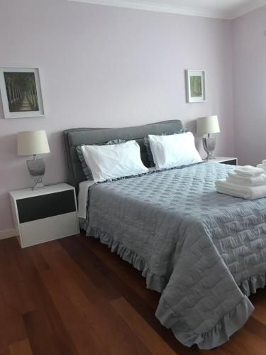a bedroom with a large bed and two lamps at Camelias in Guimarães