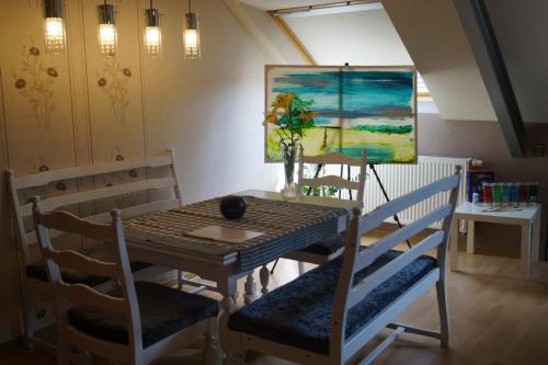 une table à manger et des chaises avec un tableau mural dans l'établissement Ferienwohnung im Grünen, à Geldern