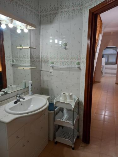 y baño con lavabo y espejo. en Duplex apartment with a large sunny terrace 200 m from the sea en La Mata