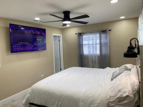 Schlafzimmer mit einem weißen Bett und einem Deckenventilator in der Unterkunft Sunny days vacation rental LLC in Orlando