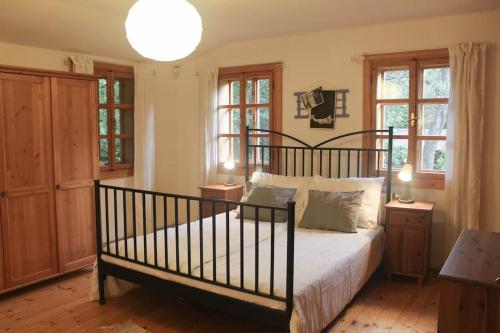 a bedroom with a large bed and two windows at Dřevěnice u Azzyho in Lačnov