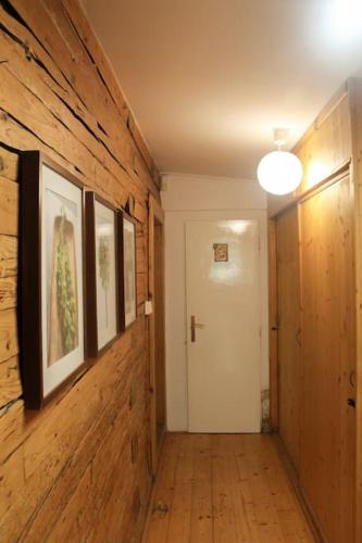 a hallway with wooden walls and a white door at Dřevěnice u Azzyho in Lačnov