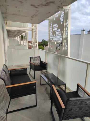 einen Balkon mit 2 Stühlen und einem Tisch auf dem Dach in der Unterkunft T2 avec balcon tout équipé 300m marché central in Royan