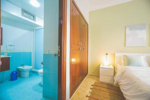 a bedroom with a bed and a bathroom with a toilet at lovely 2 bedroom vacation home with pool/beach in Skhirat