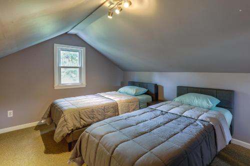 a attic bedroom with two beds and a window at Charming Monroe Township Home - 13 Mi to RU! in East Brunswick