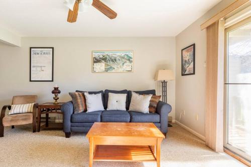 a living room with a blue couch and a table at SKIING, HIKING, VILLAGE OF EVILLE MTN ESCAPE in Ellicottville