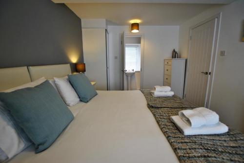 a bedroom with a large white bed with towels on it at The Cottage by the Harbour St Monans in Saint Monance