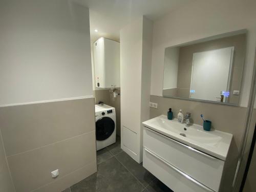 een witte badkamer met een wastafel en een spiegel bij Renovated 4 room Apartment-Parking next door and Beach at 700m in Antibes