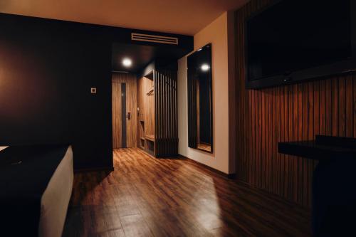 a room with a hallway with wood floors and a television at Hotel Yoru in Querétaro