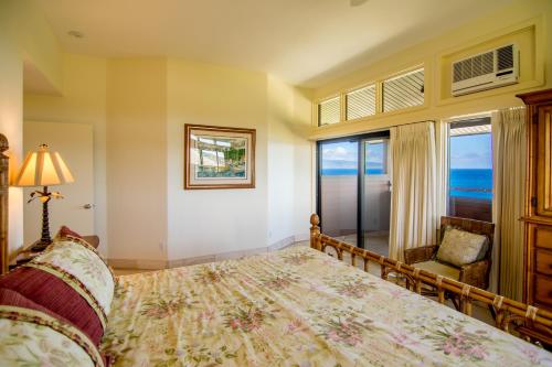 a bedroom with a bed and a chair and a window at Kapalua Villas Maui - Select Your Unit in Kahana