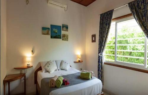 a bedroom with two beds and a large window at Maison de Vacanze in Baie Sainte Anne