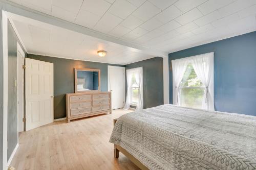 a bedroom with blue walls and a bed and a dresser at Outdoorsy Oasis with Screened Porch in Claremont in Claremont