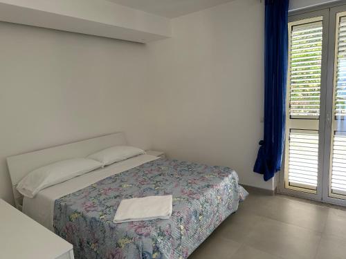 a bedroom with a bed with a towel on it at EmmeBi Appartamenti in Acquedolci