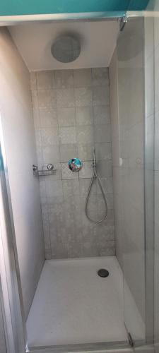 een douche met een glazen deur in de badkamer bij Villa immersa nelle colline toscane, vista vigneto in Cortona