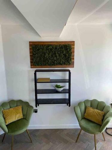 two green chairs in a room with a mirror at Sea view - 2 bedroom - West Pier - Brighton Beach in Brighton & Hove