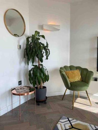 a living room with a green chair and a mirror at Sea view - 2 bedroom - West Pier - Brighton Beach in Brighton & Hove
