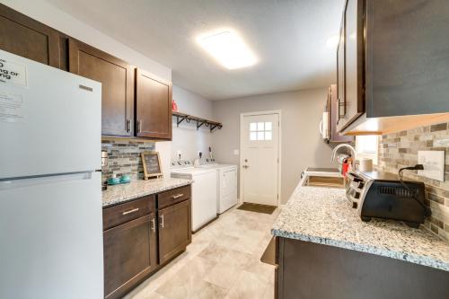 a kitchen with wooden cabinets and a white refrigerator at Deck and Patio Inviting Abode in Natrona Heights! in Natrona Heights