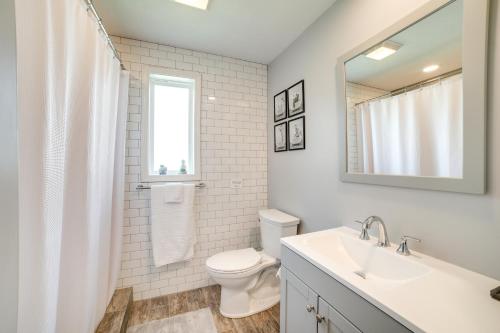 a bathroom with a sink and a toilet and a mirror at Deck and Patio Inviting Abode in Natrona Heights! in Natrona Heights
