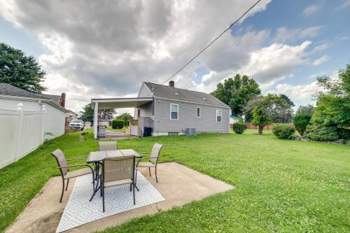 a patio with a table and chairs in a yard at Deck and Patio Inviting Abode in Natrona Heights! in Natrona Heights