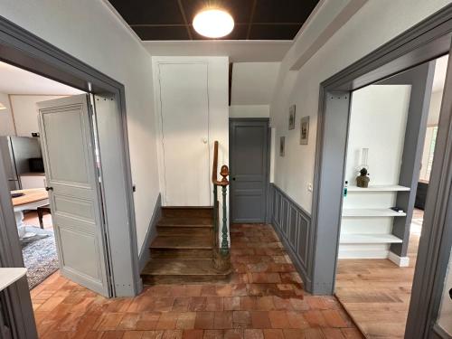 un pasillo con una puerta y escaleras en una casa en Appartement avec jardin Villeveque 