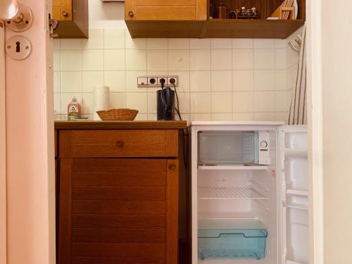 eine kleine Küche mit einem offenen Kühlschrank und Schränken in der Unterkunft Gemütliche Wohnung Bergblick in Bad Harzburg