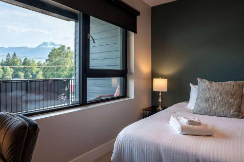 a bedroom with a bed and a large window at Northern Exposure by Revelstoke Vacations in Revelstoke