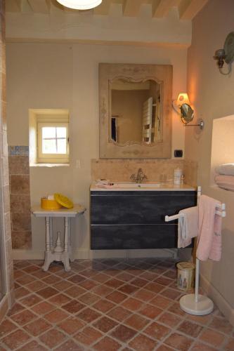 a bathroom with a tub and a sink and a mirror at La Rochelière in Bresse-sur-Grosne